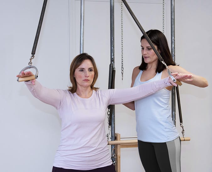 Instructor teaching a client during a private Pilates session ion a classical Pilates studio in Louisville KY