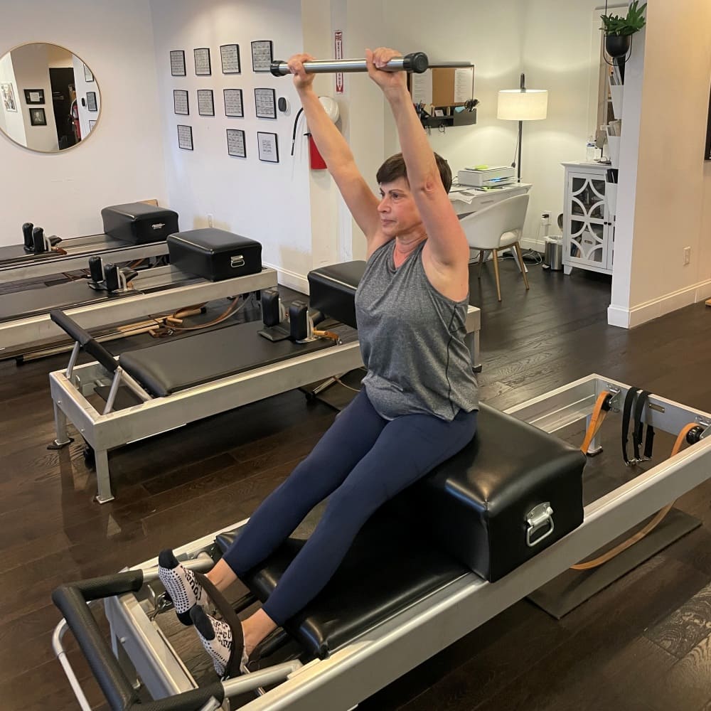 Woman taking a beginner Pilates session on the reformer at Pilates Fit Studio in Louisville KY