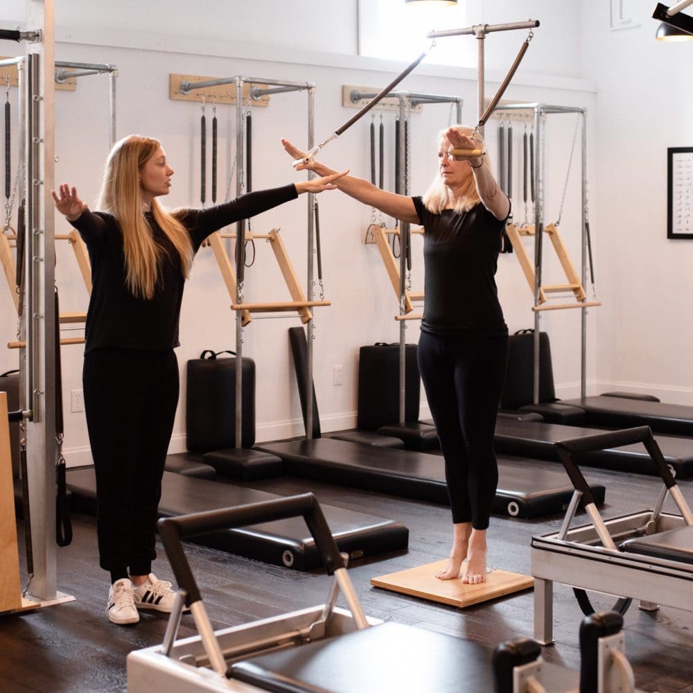Pilates instructor teacher a beginner-level Pilates session in a classical Pilates studio in Louisville  KY