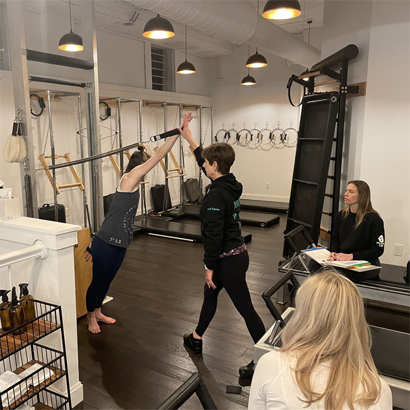 Classical Pilates teacher demonstaring an exercise during a Pilates teacher training seminar in Louisville KY