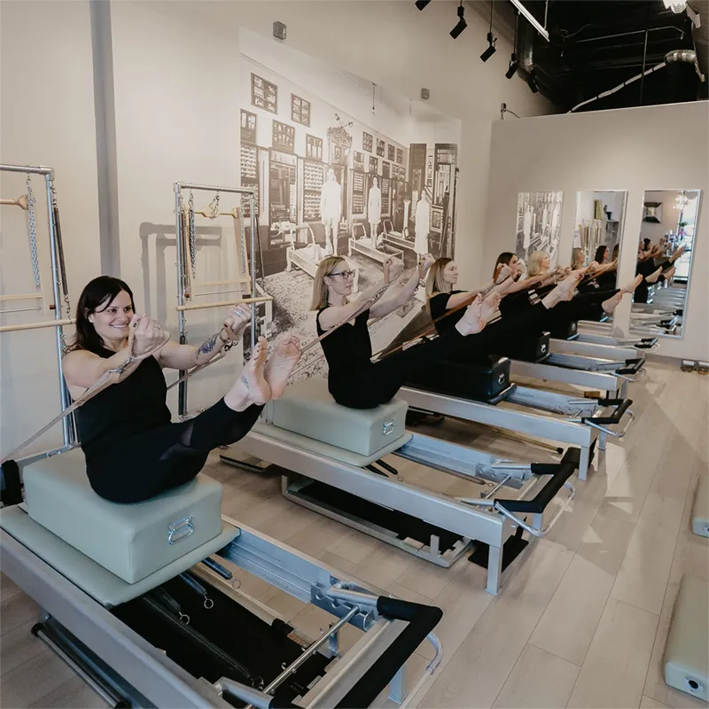 Pilates students doing a teaser on the Reformer during a classical intermediate/advanced level  class in Louisville KY
